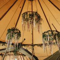 Three Hoops hang from the tipi roof, decorated with natural foliage, flowers and ribbons