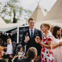Guests chat and have fun outside the tipi wedding tents