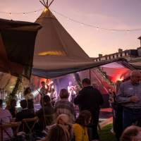 A band plays inside a Tipi, guests watch at the Rite Hite Corporate Event at the K Club Ireland