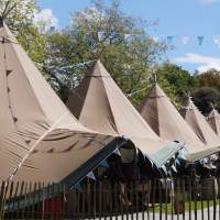 Six Tipi's line up at a food festival with colourful blue bunting decoration