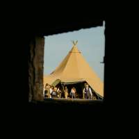 A wedding tipi is captured through an outhouse brick window