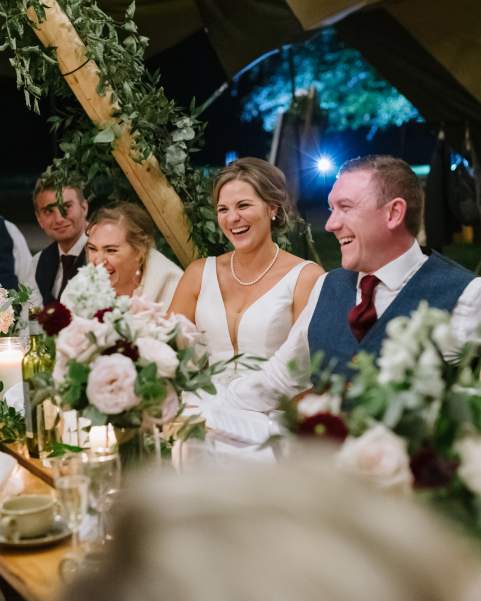 Couple and wedding party celebrate a spring wedding in a beautiful tipis