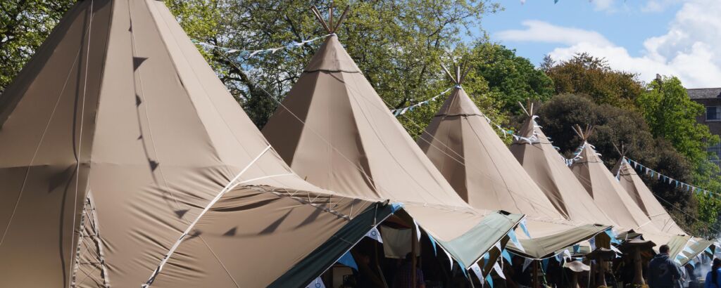 Six Tipi's line up at a food festival with colourful blue bunting decoration