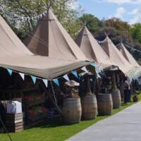 Six Tipi's line up at a food festival with colourful blue bunting decoration
