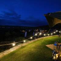 Festoon lighting on ropes are hung on Shepherd's Hooks to decorate the outside of the Dubai Duty Free Tipi Corporate Event