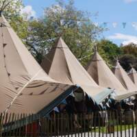 Six Tipi's line up at a food festival with colourful blue bunting decoration