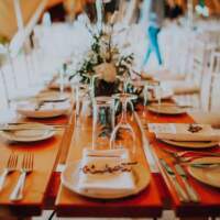 Tables are decorated with rustic wooden laser cut names and flowers