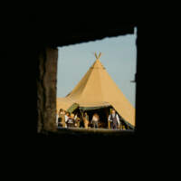 A wedding tipi is captured through an outhouse brick window
