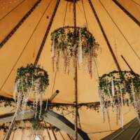 Three Hoops hang from the tipi roof, decorated with natural foliage, flowers and ribbons