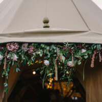 Gorgeous flowers and foliage decorate the Tipi door entrance