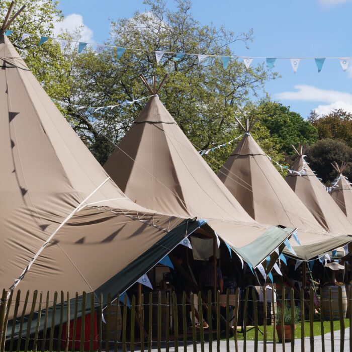 Six Tipi's line up at a food festival with colourful blue bunting decoration