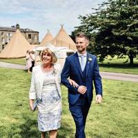 Wedding guests walk to the ceremony site, the family estate, three Tipis and a vintage volkswagen van