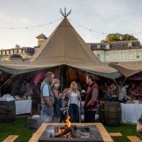 Guests talk in front of open Tipis at the Rite Hite Custom Ireland Corporate Event