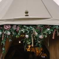 Gorgeous flowers and foliage decorate the Tipi door entrance