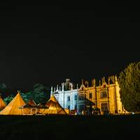 Narrow Water Castle and a four Tipi wedding setup are highlighted with warm lights at night