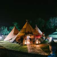The entrance to the Tipi wedding reception is highlighted with light and two lanterns at night